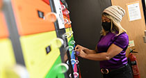 Student at laptop locker wearing face mask
