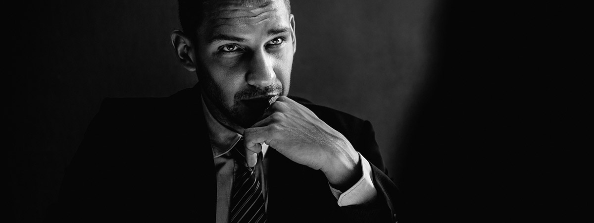Top Four Reasons to be a Criminologist 1200x450 - Man sat in a dark room