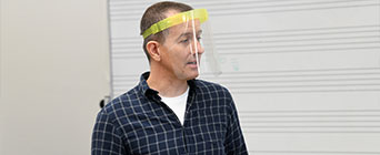 Teacher in class wearing visor.