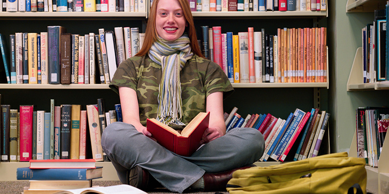 A woman sitting and reading in the library