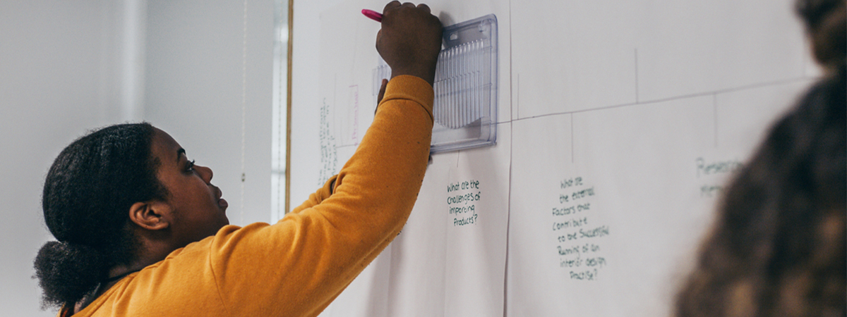 PG student writing on whiteboard